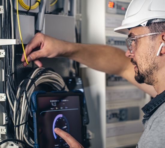 Smart Home Security Installation 4 man electrical technician working switchboard with fuses 2 1 - Security Camera Santa Cruz